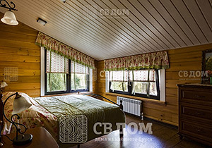 Уютная спальня в доме из клееного бруса